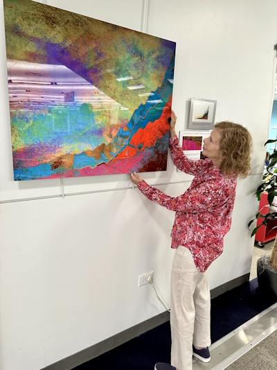 A photo of climate artist Alisa Singer and her art on display at Northbrook Public Library