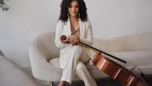 A photo of a woman on a couch holding a cello