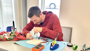 A person repairing an item at a table