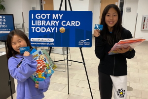 A photo of two girls holding library cards.