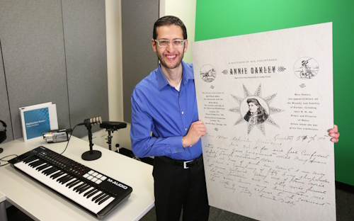 Ari Siegel holds up a historical artifact in Northbrook Public Library's Digital Media Lab