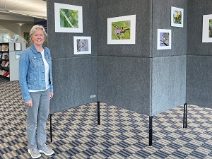 Lisa Musgrave stands next to her photo exhibit