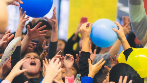 Image of kids reaching for balloons