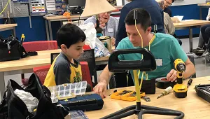 A photo of a volunteer helping to repair an item.