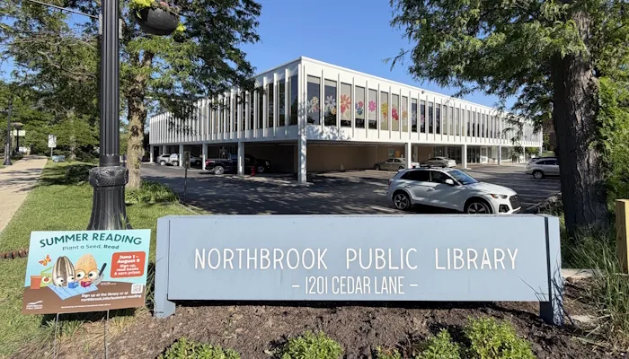 The library sign and a Summer Reading yard sign